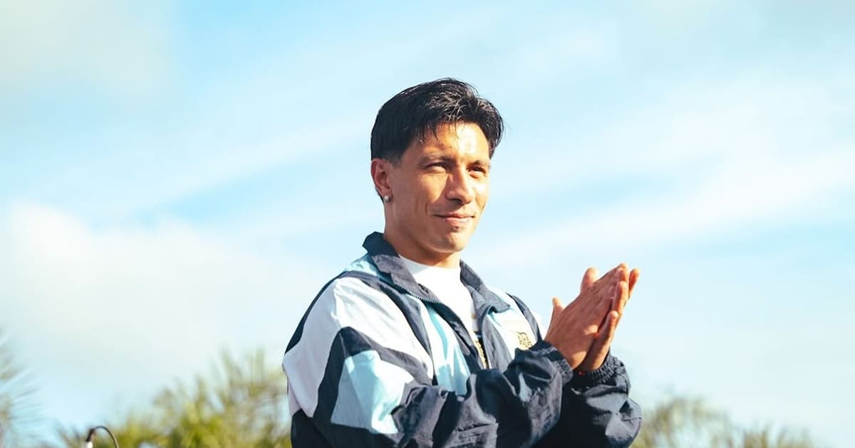 a man in a blue jacket is standing on a rock